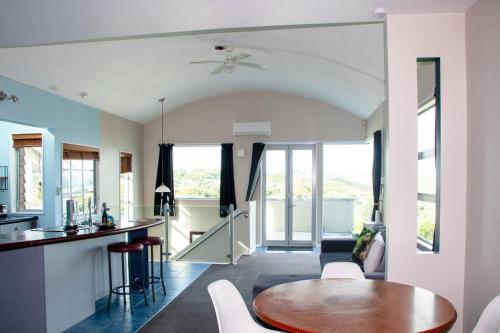 a kitchen and living room with a table and chairs at Comfort in Khandallah in Wellington