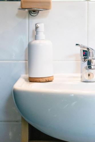 a soap dispenser sitting on top of a bathroom sink at Comfort in Khandallah in Wellington