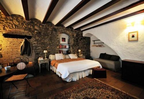 - une chambre avec un lit et un mur en briques dans l'établissement Casa Matilda Bed and Breakfast, à Corçà