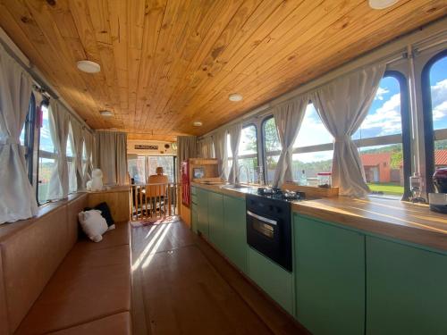 a kitchen with a wooden ceiling with windows in it at Sal da Terra Bus in Pirenópolis
