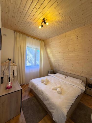 una camera da letto con un letto con due asciugamani sopra di Catunu lupului village Cabana Monte Benito a Cotorăşti