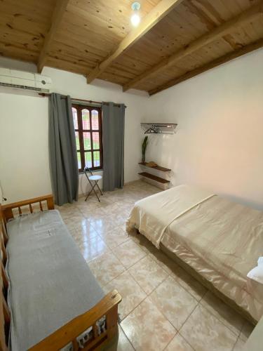 una camera da letto con due letti e soffitto in legno di Alma del Pinal a Garupá