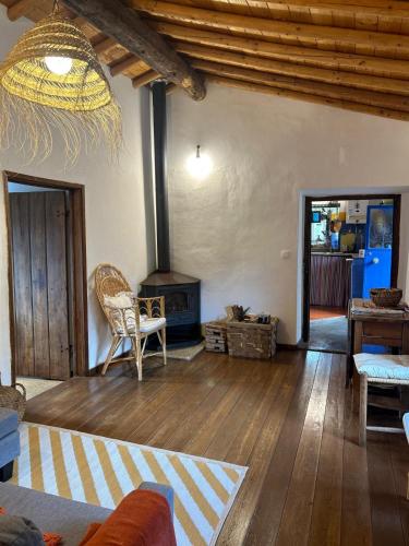 a living room with a fireplace and a wooden floor at Art-Marvão, Alojamento Rural in Marvão
