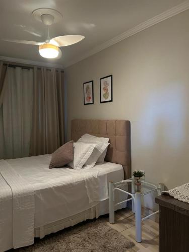 a bedroom with a bed and a table in it at Recanto familiar in Florianópolis