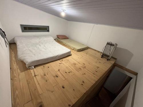a small room with a bed and a wooden floor at Chalé a Beira em Arroio do Sal in Arroio do Sal