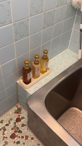 a bathroom with a sink with three bottles of soap at りんくう館笠松 関西空港 in Sano