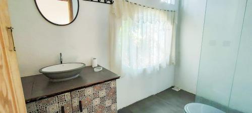 a bathroom with a sink and a mirror at Chalé a Beira em Arroio do Sal in Arroio do Sal