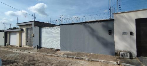 a building with two garage doors and a fence at Casa, Perto de Praias, Shoppings e Valparaíso in Maioba
