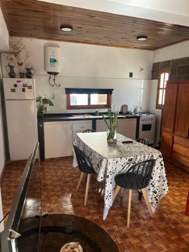 a kitchen with a table and a kitchen with a refrigerator at Departamento cómodo in Concepción del Uruguay