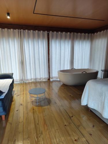 een slaapkamer met een bad, een bed en een tafel bij Cabana Penélope in Alfredo Wagner