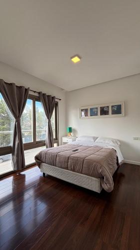 ein Schlafzimmer mit einem Bett und einem großen Fenster in der Unterkunft Costanera Sur Departamento in Río Gallegos
