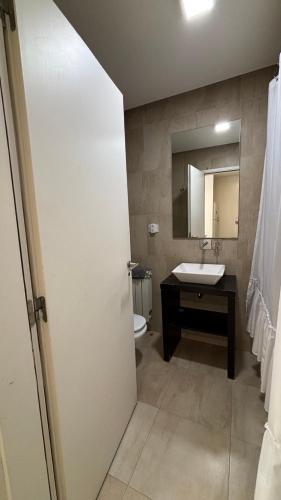 ein Badezimmer mit Waschbecken, Toilette und Spiegel in der Unterkunft Costanera Sur Departamento in Río Gallegos