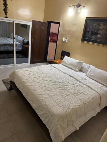 un grande letto bianco in una stanza con una camera da letto di Ô Bien Être a Saint-Louis