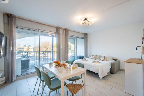 ein Wohnzimmer mit Tisch und Bett in der Unterkunft Large Studio Waterfront Air-conditioned Beach 1 min away in La Celle-sous-Gouzon