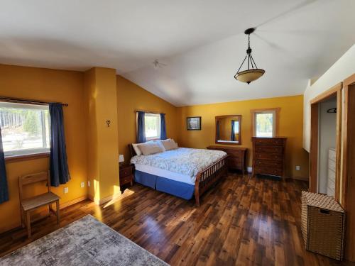 een slaapkamer met gele muren, een bed en houten vloeren bij 1st Chair Mountain Resort in Nelson