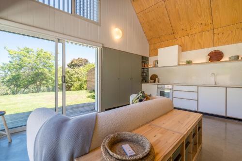 een woonkamer met een bank en een groot raam bij The Hillside Project in Frankston South