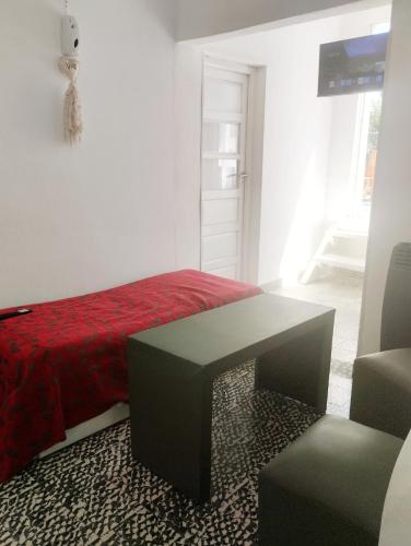 een slaapkamer met een rood bed en een tafel bij Vm casa in Villa María