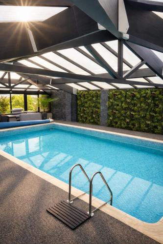 a large swimming pool with a roof at Glandwr hall - 6 Bed - Magnificent Country House with Heated Swimming Pool & Jacuzzi in Barmouth