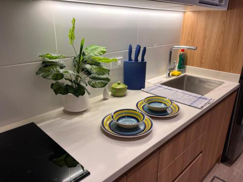 a kitchen counter with two plates and a sink at Nuevo y moderno departamento Quito Norte in Quito