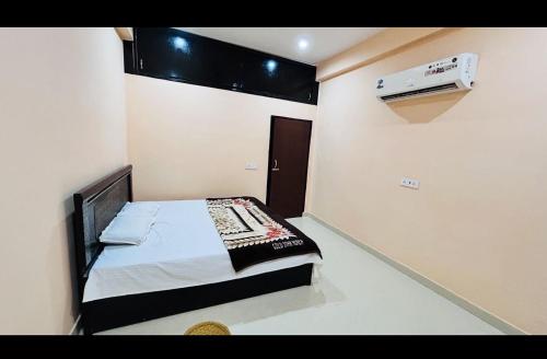 ein kleines Schlafzimmer mit einem Bett und einer Klimaanlage in der Unterkunft shri radha ji guest House in Vrindāvan