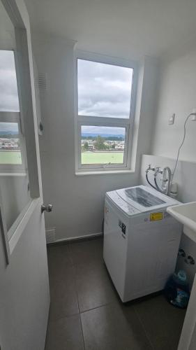 a laundry room with a window and a washing machine at Departamento Villarrica in Villarrica