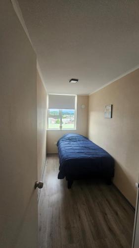 a bedroom with a bed in a room with a window at Departamento Villarrica in Villarrica