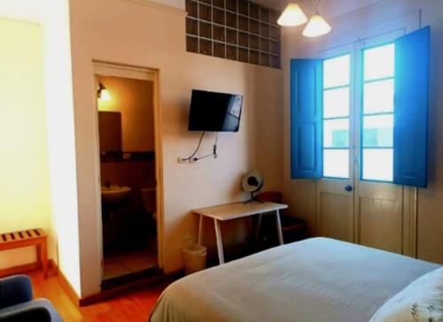 een slaapkamer met een bed en een tv aan de muur bij Santa Marta Casona in Arequipa