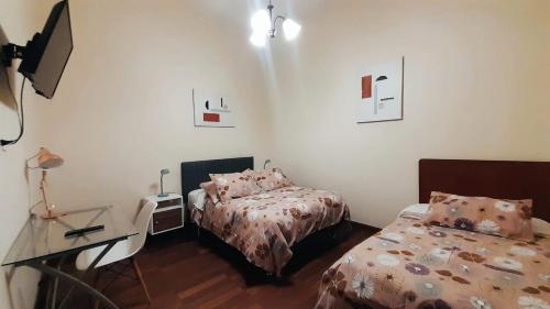 een kamer met 2 bedden en een bureau met een bureau bij Santa Marta Casona in Arequipa