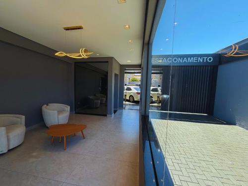 a view of a living room with a table and a couch at Damani Studios in Foz do Iguaçu