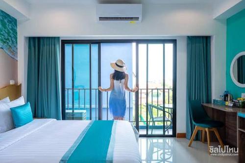 een vrouw op een balkon met uitzicht op de oceaan bij Jomtien Beach Market Place in Jomtien Beach
