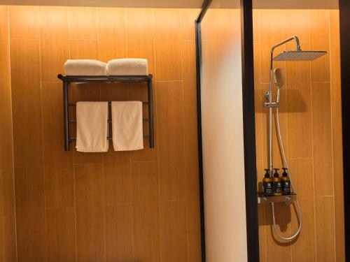 a bathroom with a shower and towels on a wall at 先泽酒店 in Huadu