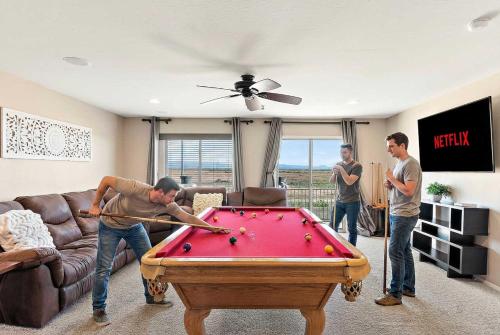 a group of three men playing pool in a living room at Sleeps 14 Pool Fire Pit Billiards EV Plug in Mesa