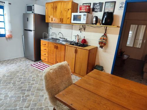 - une cuisine avec des placards en bois, une table et un réfrigérateur dans l'établissement Sossego na Serra Catarinense - Casa em Lages, à Lages