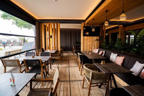 an empty restaurant with wooden tables and chairs at KARIBU - Olifant in Kasterlee