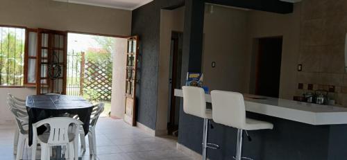 een keuken met witte stoelen en een aanrecht bij La Calandria in Cerrillos