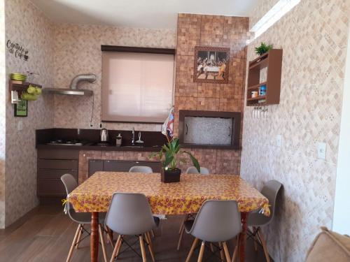 una cucina con un tavolo e sedie in una stanza di ESTÚDIO "Coisa de Daiane" a São Gabriel