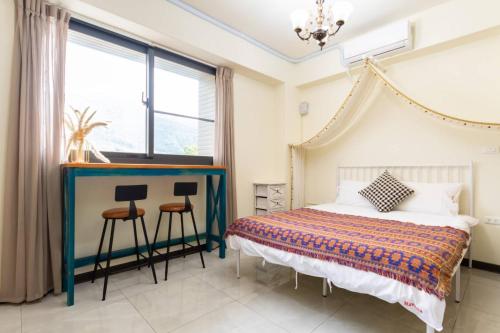 een slaapkamer met een bed en een raam bij 巨翼包棟民宿 in Puli