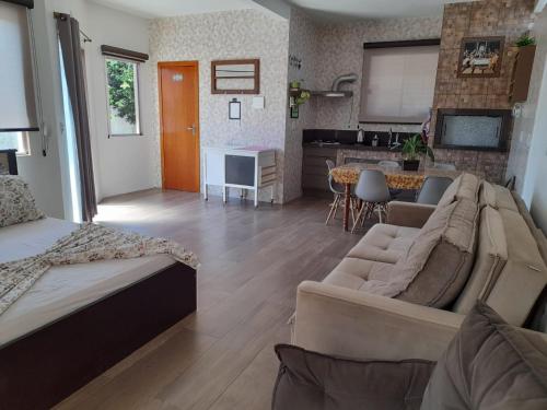 un soggiorno con divano e cucina di ESTÚDIO "Coisa de Daiane" a São Gabriel