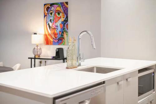 una cucina bianca con lavandino e quadro di Charming condo in Rosemont a Montréal