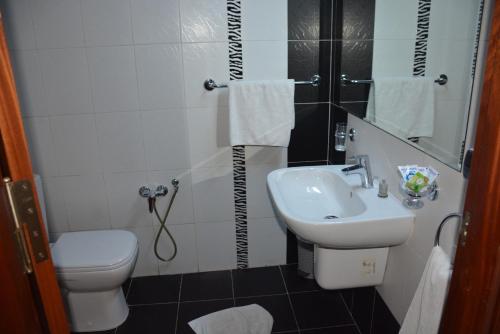 een kleine badkamer met een wastafel en een toilet bij Pacha hotel in Sfax