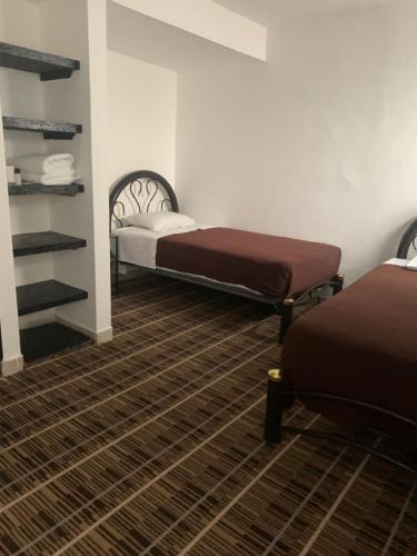 a room with two beds in a room at Kuku Ruku Hotel in Querétaro