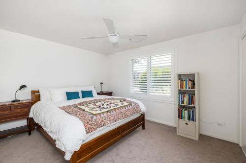a bedroom with a bed and a book shelf at Verona in Shoal Bay