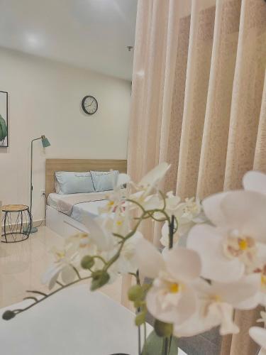 a room with a bed and a table with white flowers at Căn hộ Studio 33m2 tòa S217 in Gia Lâm Pho