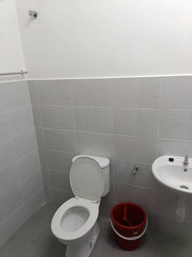 a bathroom with a toilet and a sink at Homestay Gapam Kasih in Bemban