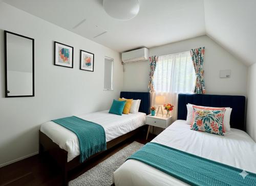 a bedroom with two beds and a window at Brand New Modern Haven 7-Min Walk to Shinkoenji Station 9-Min Train to Shinjuku in Tokyo