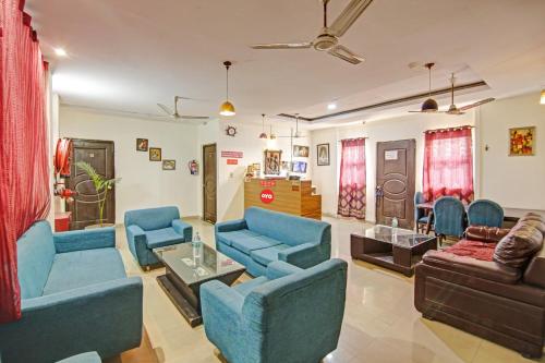 a living room with blue chairs and a couch at Super Hotel O Glorious Stayz in Noida