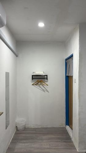 a room with a white wall with a shelf on the wall at Trong Roomstays in Terong