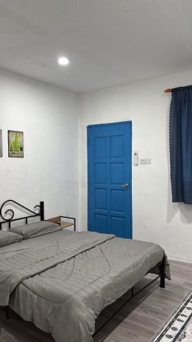 a bed with a blue door in a bedroom at Trong Roomstays in Terong