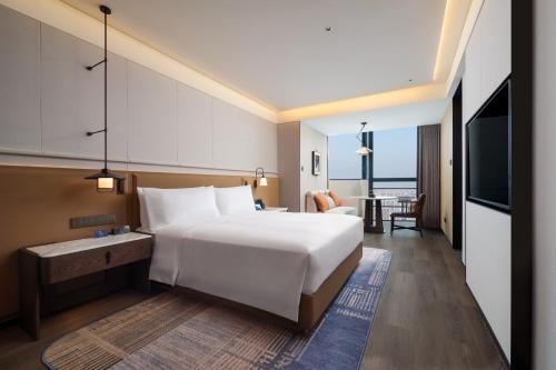 une chambre d'hôtel avec un grand lit et une table dans l'établissement DoubleTree by Hilton Zhangzhou, à Zhangzhou