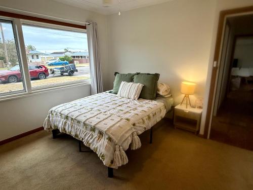 a bedroom with a bed in front of a window at Saltwater Escape in Swansea